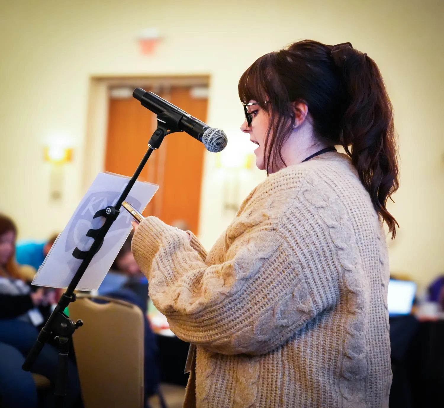 A KNEA Representative Assembly Delegate at a microphone at the 2026 KNEA RA in Wichita.