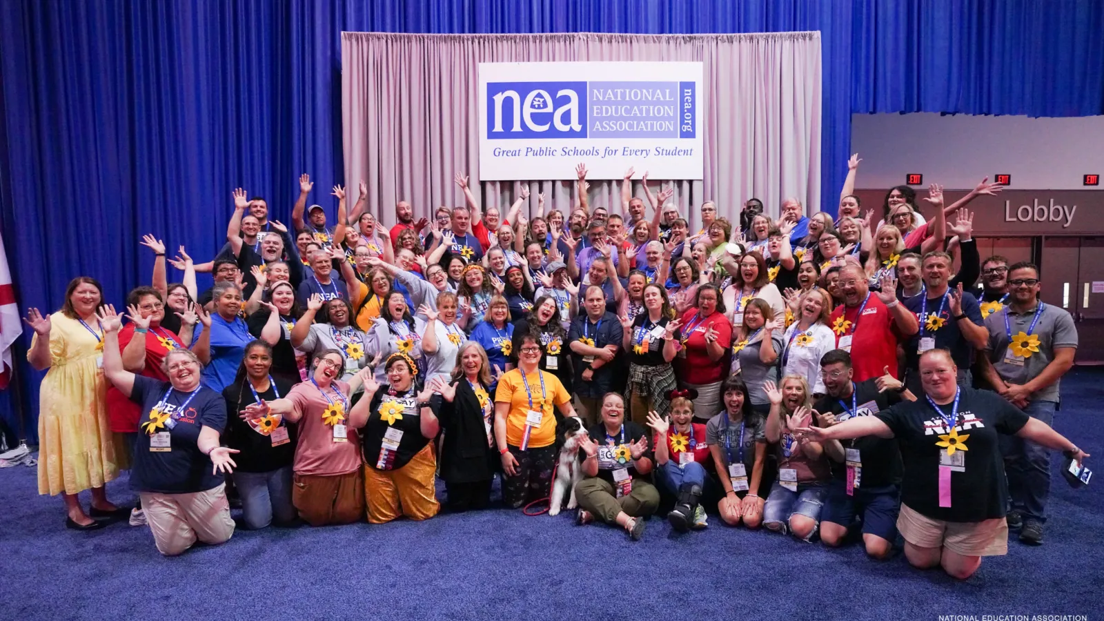 KNEA "fun" delegation photo from the 2023 NEA RA. Elected KNEA delegates pose in front a backdrop and NEA banner with big smiles and fun poses.