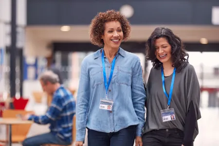 Two teachers walk through a hallway